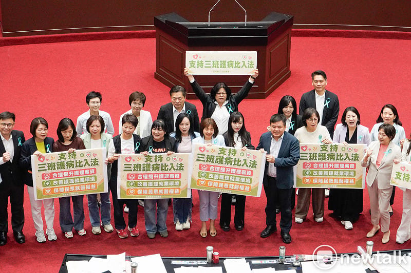  立法院三讀通過「醫療法部分條文修正草案」後，民進黨立委在議場內舉牌支持「三班護病比」入法。 圖：張良一/攝 