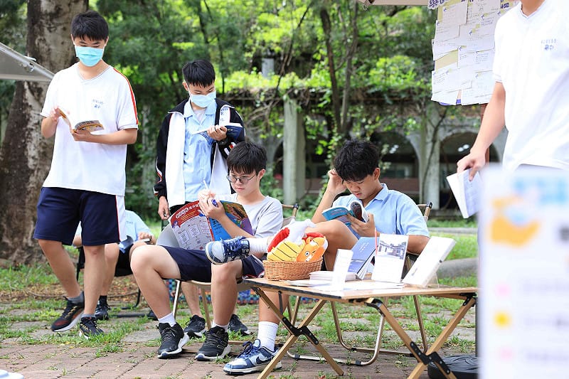  學生們在故事車所設置的戶外露營風格閱讀區專心翻閱書籍。 圖：國家人權博物館提供 