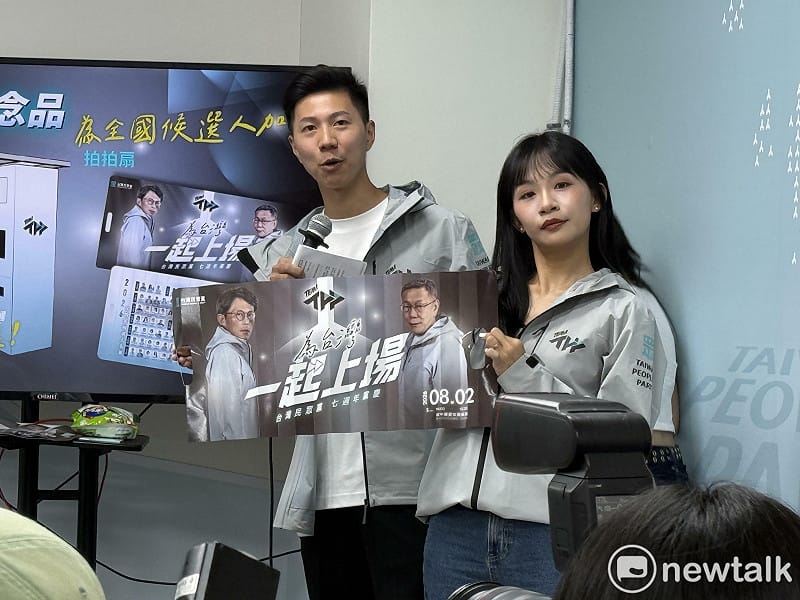  民眾黨副秘書長李頂立、黨發言人張彤展示本次黨慶的小物拍拍扇。 圖：周煊惠 / 攝