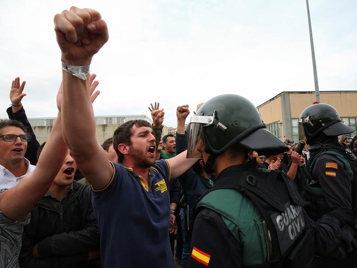 在巴塞隆納獨立公投投票所外面，民眾與鎮暴警察對峙中。   圖：達志影像／路透社