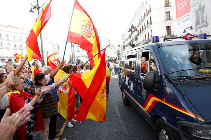 在首都馬德里，支持西班牙維持統一的民眾揮舞旗幟，向路過的警車致意。   圖：達志影像／路透社