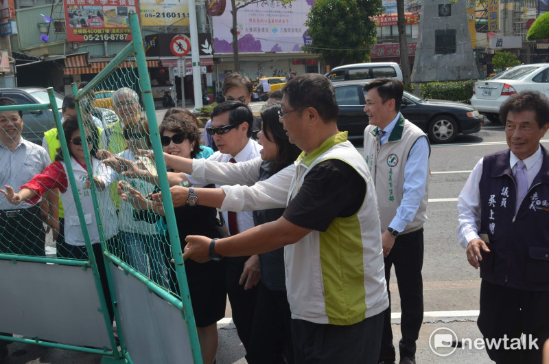 嘉義市長涂醒哲與多名來賓推倒圍欄，象徵開啟嘉義車站新的門面。   蔡坤龍/攝