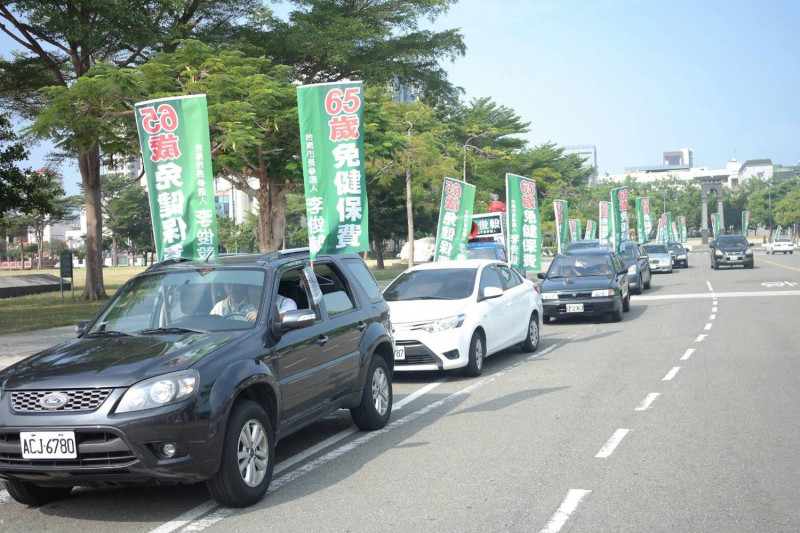 台南市長參選人李俊毅為突顯此問題，在台南市區以「65歲以上老人免繳健保費」為訴求進行車隊遊行。   圖：黃博郎／攝
