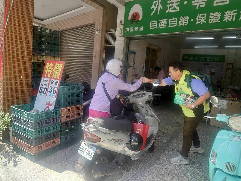 薛兆基(右)徒步穿越左營，逢人即握手問候、恭敬遞上文宣。   圖：薛兆基/提供