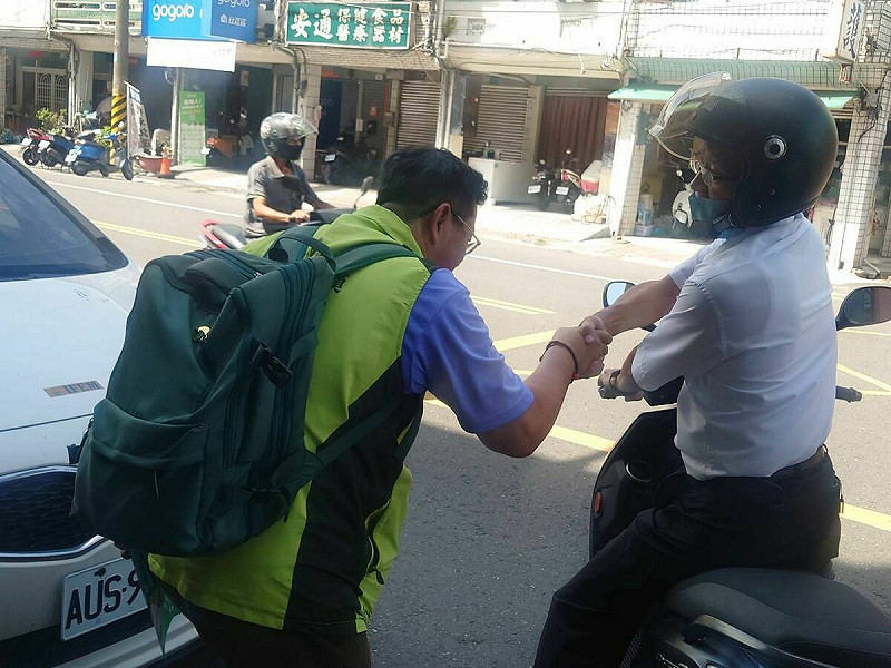 薛兆基(左)遇見路過的騎士也上前握手問候。 圖:薛兆基/提供
