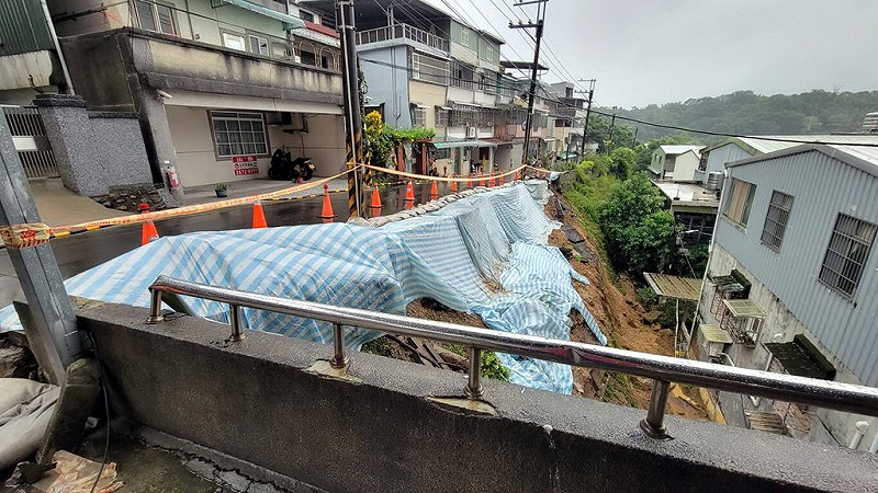 受東北季風及東邊低壓影響，迎風面的大台北地區、宜蘭山區降雨仍明顯且持續，新北市三峽區二鬮路22日發生邊坡土石滑落，已經暫時鋪上帆布，設封鎖警示。（三峽區公所提供）中央社記者黃旭昇傳真　114年10月22日   