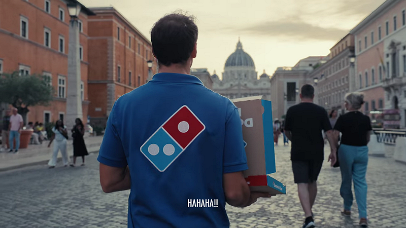 國際連鎖披薩品牌達美樂(Domino’s)最近腦洞大開,派出員工親手捧著一份鳳梨披薩,穿越梵蒂岡每25年才會開啟一次的「聖彼得大教堂聖門」。這扇門象徵赦免一切罪孽,而達美樂官方也幽默宣布:「從今天起,吃夏威夷披薩不再是罪行!」 圖:翻攝自影片