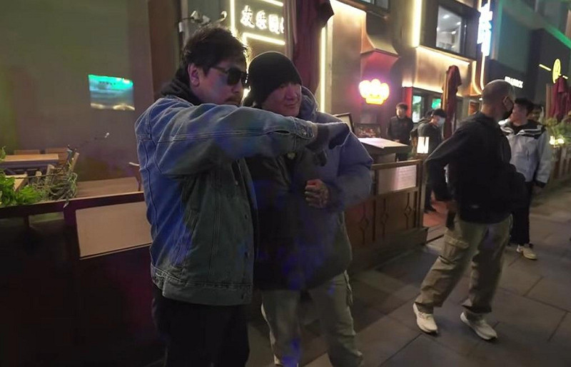 館長陳之漢北京行,遇到一名神秘男子上前合照,不僅比出倒讚,還在耳邊親嗆一邊一國,引發熱議。   圖:翻攝自館長惡名昭彰