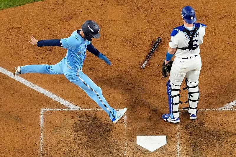 美國職棒世界大賽第5戰,多倫多藍鳥隊的安德烈斯吉梅內斯(左)在第七局越過洛杉磯道奇隊的捕手威爾史密斯(右)得分。   圖:(美聯社)