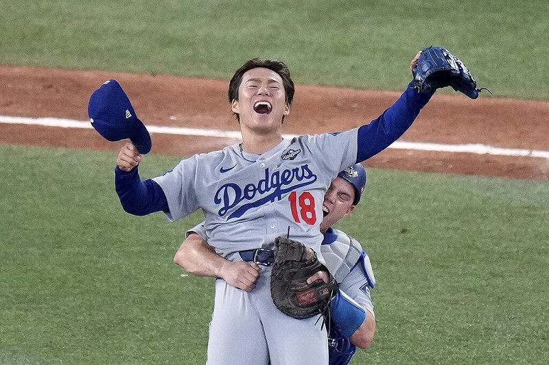 MLB洛杉磯道奇日籍強投山本由伸（前）1日力繳2.2局完美壓制對手，賽後他被捕手史密斯抱起慶祝勝利。（Chris Young/The Canadian Press via 美聯社）   