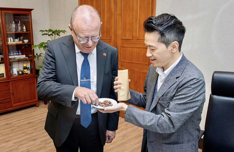 何志偉拿出台灣種的可可豆給瑞士聯邦國會友台小組共同主席阿多爾（Jean-Luc Addor）品嚐。   圖：翻攝自何志偉臉書