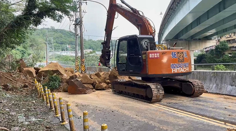 基隆市暖暖區興隆街一處邊坡7日下午崩塌，落石占據路面導致交通中斷，市府獲報迅速調派怪手、鏟裝機、卡車及工程人員到場搶修。（讀者提供）中央社記者王朝鈺傳真　114年11月7日   