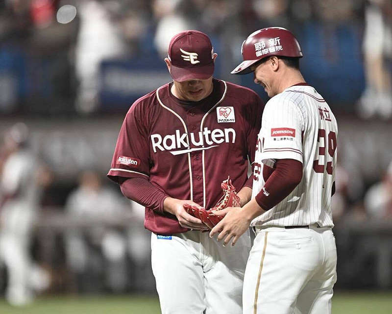 2025年亞洲職棒交流賽8日樂天桃猿與日職樂天金鷲隊交手，中華職棒樂天桃猿隊野手林立（右）站一壘指導員，樂天金鷲投手宋家豪（左）下場作勢要給他檢查手套、互動有趣。（桃園市政府提供）中央社記者謝靜雯傳真 114年11月9日   