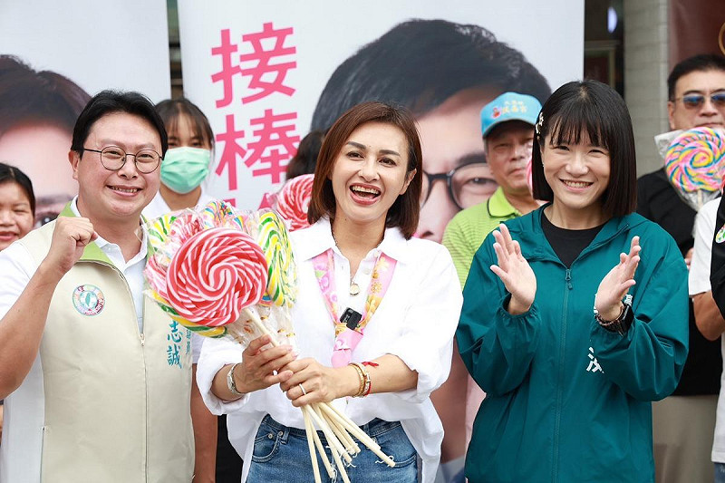 邱議瑩(中)從陳其邁子弟兵手中接下棒棒糖，象徵將接棒陳其邁延續高雄進步價值。   圖：邱議瑩競選總部/提供