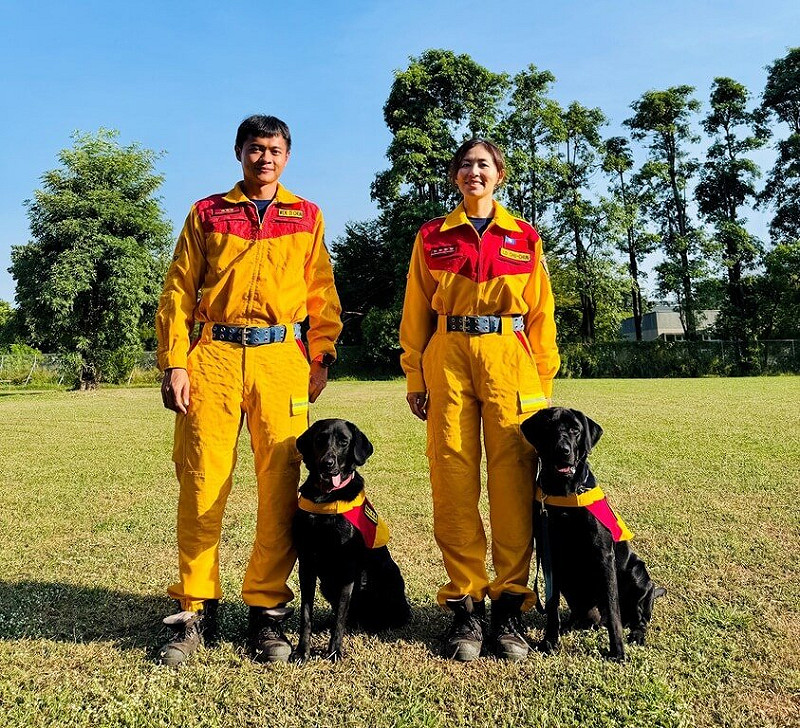 基隆市消防局特種搜救隊編制1對拉布拉多犬兄妹檔，歷經1年6個月訓練，日前通過國際搜救犬組織A級評量，取得國際認證。圖為通過評測的為領犬員小隊長羅竹君（右）與搜救犬克林（Clint）、及隊員温堤鈞（左）與搜救犬甘蒂絲（Candice）。（基隆市消防局提供）中央社記者王朝鈺傳真　114年11月10日   