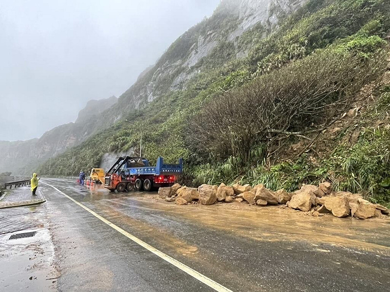颱風鳳凰逼近，新北市萬里區港西路國聖公墓旁邊坡，11日凌晨崩落，石塊占據1線車道，區公所接獲通報，立即請廠商調派人員和機具趕赴現場，並於上午8時許清除完畢，開放通行。（萬里區公所提供）中央社記者王朝鈺傳真　114年11月11日   