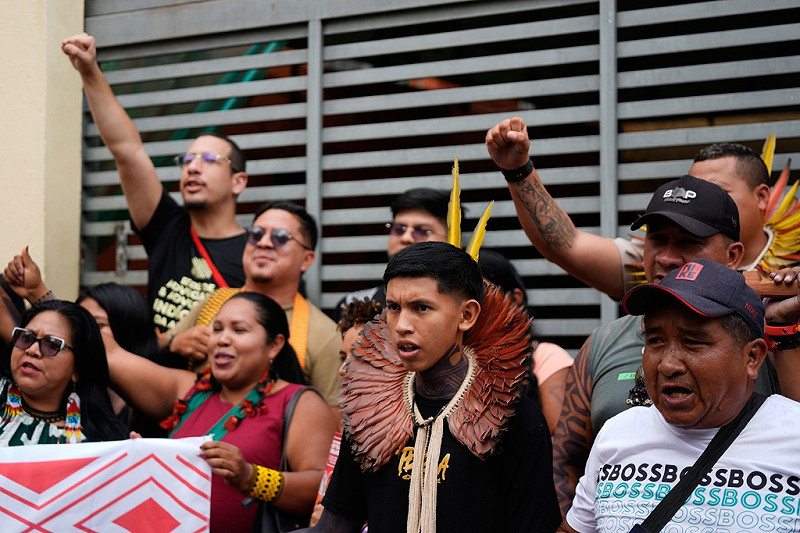 抗議者高舉旗幟與標語，呼籲土地權利與反對資源開發。   圖：達志影像／美聯社