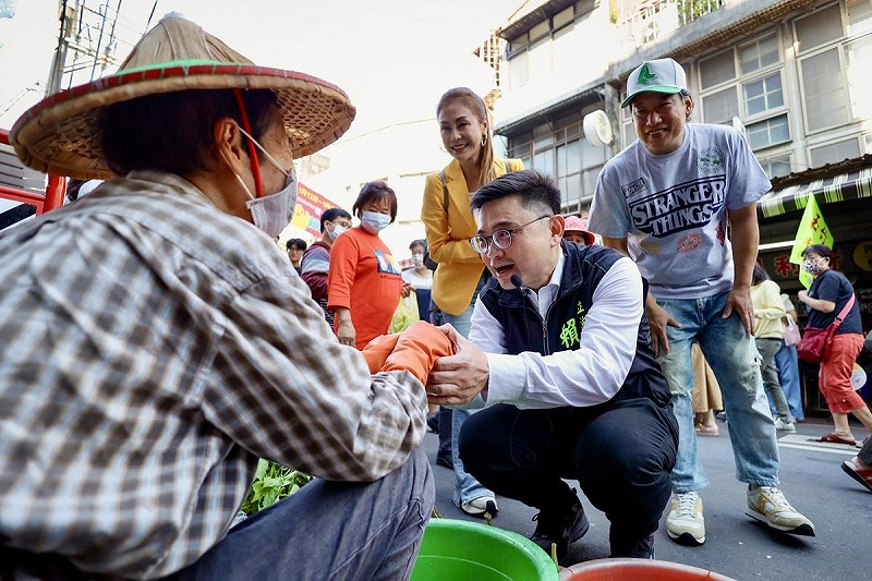 賴瑞隆(右二)蹲下身與菜販握手。   圖：賴瑞隆辦公室/提供