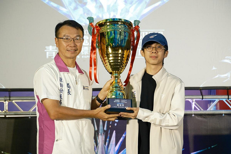 侯尊堯(左)頒發Ugang(右)「2025全國電競青年錦標賽」《快打旋風6》總決賽冠軍獎杯。   圖：高雄市運發局/提供
