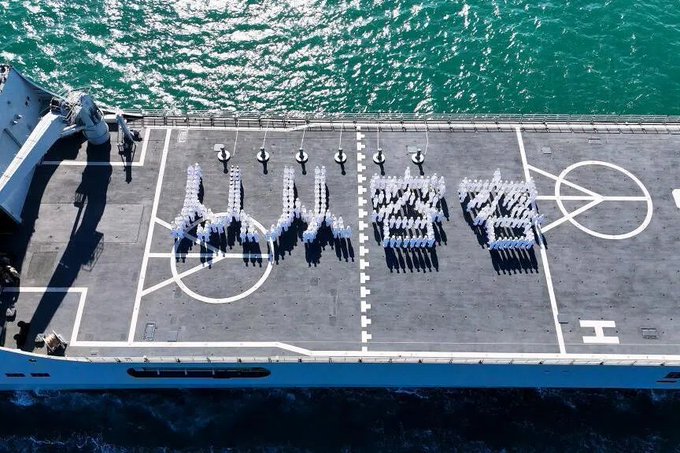中國海軍 989 編隊近期從山東青島出發，準備航向東南亞地區，並針對船上學員進行實習訓練。在出航前，學員在甲板上排出「從從容容」、「游刃有餘」等字樣，並拍下空拍照片。   圖：翻攝自 @xiaolefan2 X 帳號