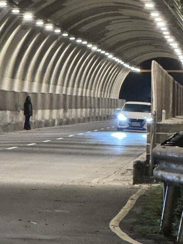 賴姓男子10月26日晚間騎車經基隆市中山隧道，看到長髮黑衣女（圖）站在道路，引發網路「女鬼」熱議。警方追查，岩女、李男和江男稱為拍攝靈異短片，基隆地方法院11月17日裁定3人各處罰鍰新台幣5000元。（賴姓男子提供）中央社記者王朝鈺傳真　114年11月20日   