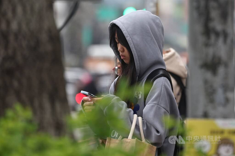 氣象專家吳德榮表示，24日晚起東北季風增強，北台灣氣溫下降。圖為新北市土城區外出民眾穿起連帽上衣禦寒。（中央社檔案照片）   