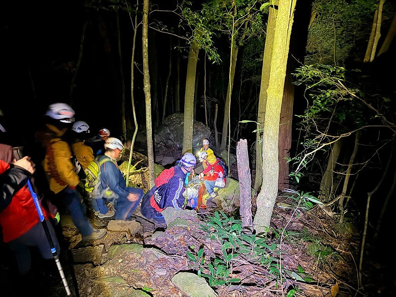 苗栗消防局24日表示，一行6人登山隊伍攀登苗栗南庄加里山，其中1名男子不慎滑倒腳踝脫臼，共調派21名救難人員分3梯次上山徒步接力搬運，耗時8個多小時終將患者抬下山就醫。（苗栗縣消防局提供）中央社記者管瑞平傳真　114年11月24日   