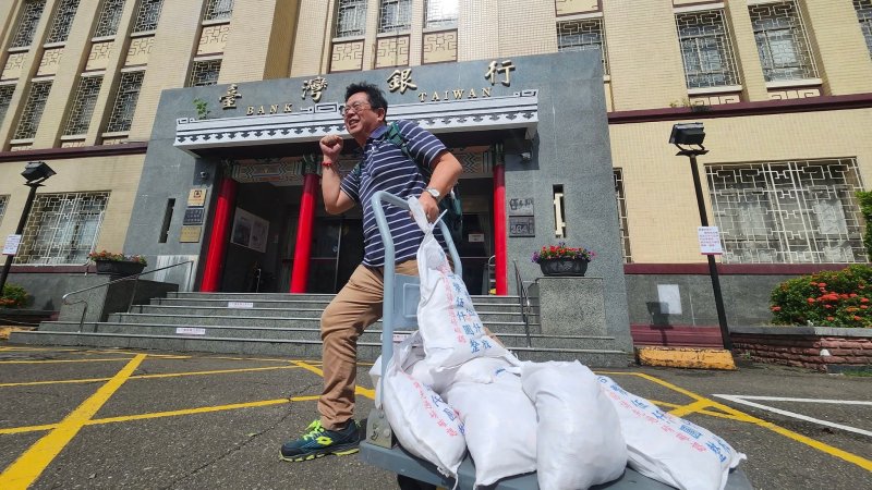 薛兆基推著滿滿一車白色硬幣袋走出台灣銀行。   圖：翻攝薛兆基臉書