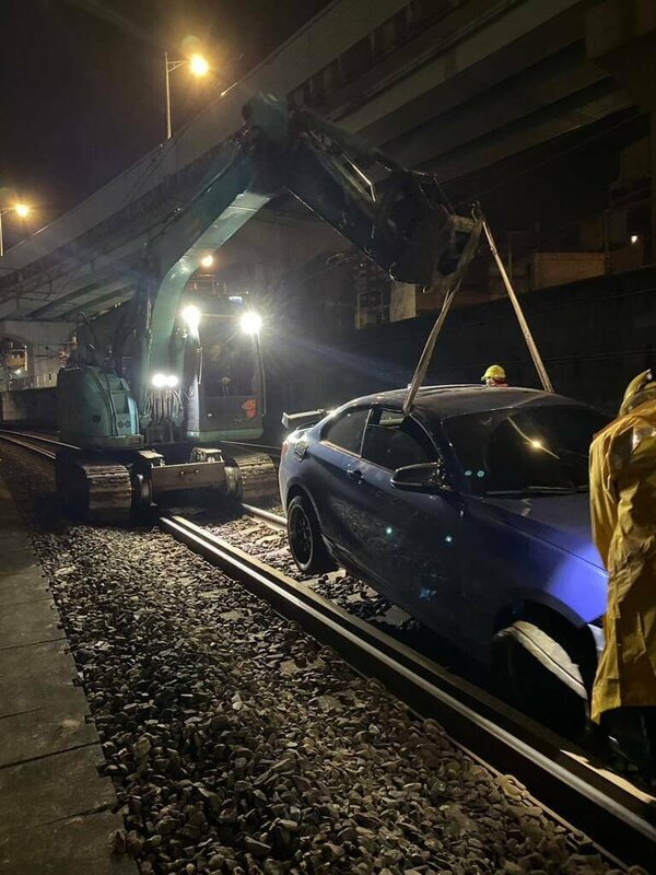 通緝犯黃姓男子26日凌晨2時許開車拒檢，衝入基隆市一處平交道，飆駛鐵軌不久後爆胎，黃男棄車逃逸；台鐵調派怪手於凌晨4時50分將車輛移到路線外。（讀者提供）中央社記者王朝鈺傳真　114年11月26日   