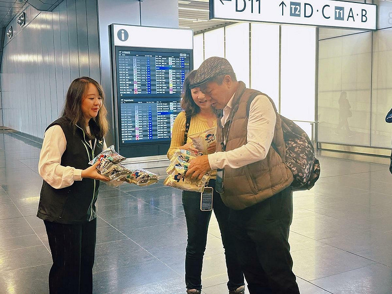 工作人員贈送限量版乖乖餅乾，祝福大家在全新北登機廊廳的陪伴下平安順飛。&nbsp;&nbsp;&nbsp;圖：桃園機場公司／提供