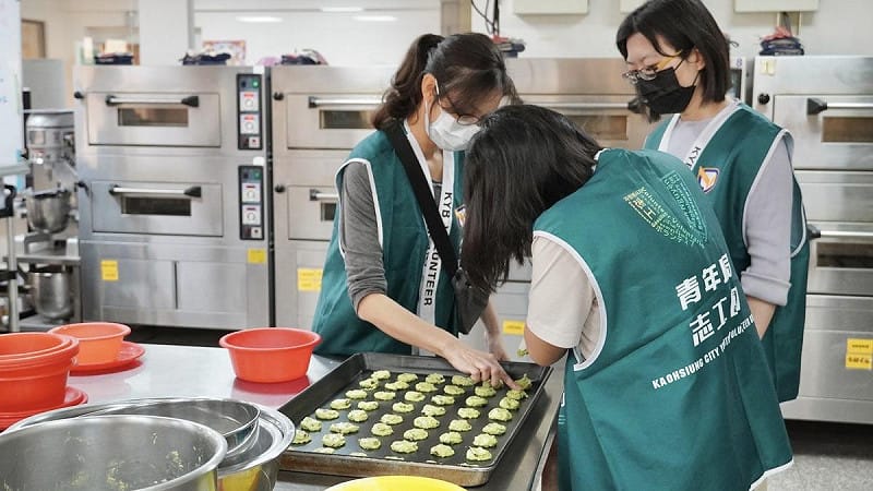 「青年志工團」細心擺放餅乾麵糰，透過實作將愛心化作甜蜜點心。   圖：高雄市青年局/提供