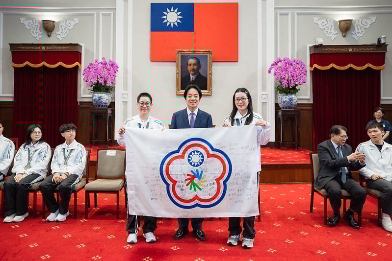  聽奧選手回贈賴清德達福林匹克運動會的吉祥物，以及選手代表的簽名旗。 圖：總統府提供 