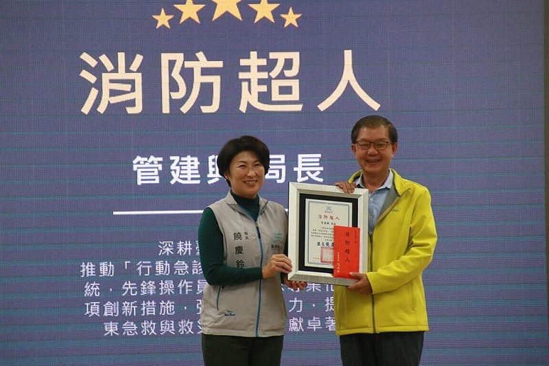 擔任台東縣消防局長27年、在消防服務逾40年的管建興（右），即將在115年1月退休，台東縣長饒慶鈴（左）4日頒贈「消防超人」獎牌，感謝他始終堅守救災第一線。（台東縣政府提供）中央社記者盧太城台東傳真　114年12月5日   