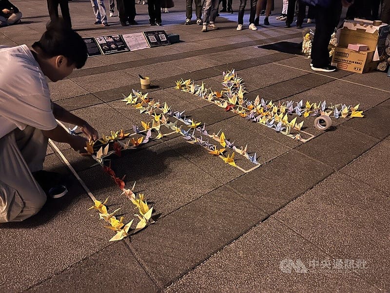 在台港人組成香港宏福苑火災台灣悼念關注組，6日晚在中正紀念堂自由廣場舉辦悼念晚會，現場用民眾手折紙鶴填滿「HK」字樣。   圖:中央社提供