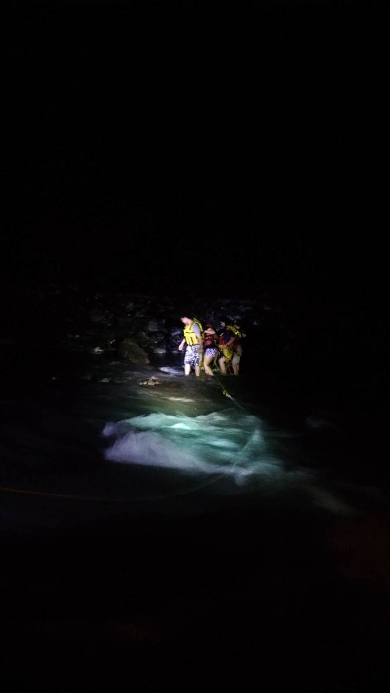 飛龍瀑布下游處昨天傍晚因溪水暴漲，4名印尼籍人士無法過河受困，屏東縣消防局獲報前往救援。   圖:屏東縣消防局提供