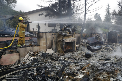 加州消防員正灑水降溫，以防火勢再起。   圖：達志影像/美聯社