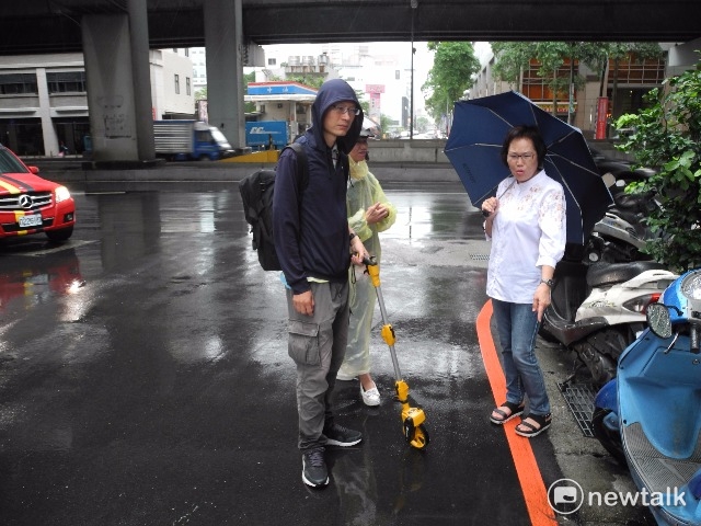 市議員林秀惠（右）與交通局人員冒雨測量巷道。   圖 : 王俊昌/攝影