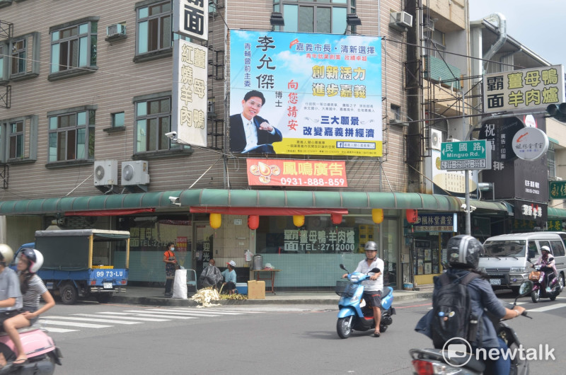 嘉義市長參選人李允傑18日於民國、民權路口懸掛選舉看板。   圖 : 蔡坤龍/攝