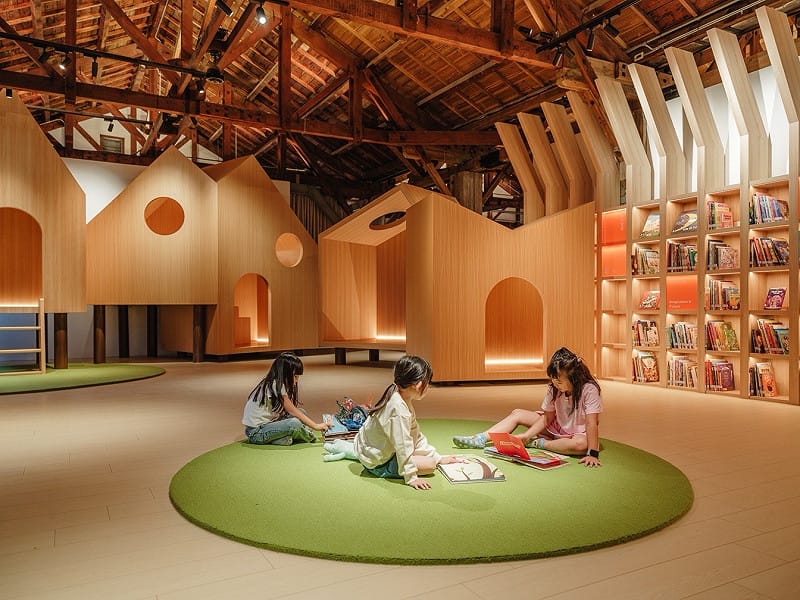 「繪本故事屋」設計保留建物木屋架的質地與歲月痕跡，以自然意象回應場域記憶，包含森林般的木質層層框架、流動如水景的動線、樹洞與小屋般的閱讀角落。&nbsp;&nbsp;&nbsp;圖：文化部提供
