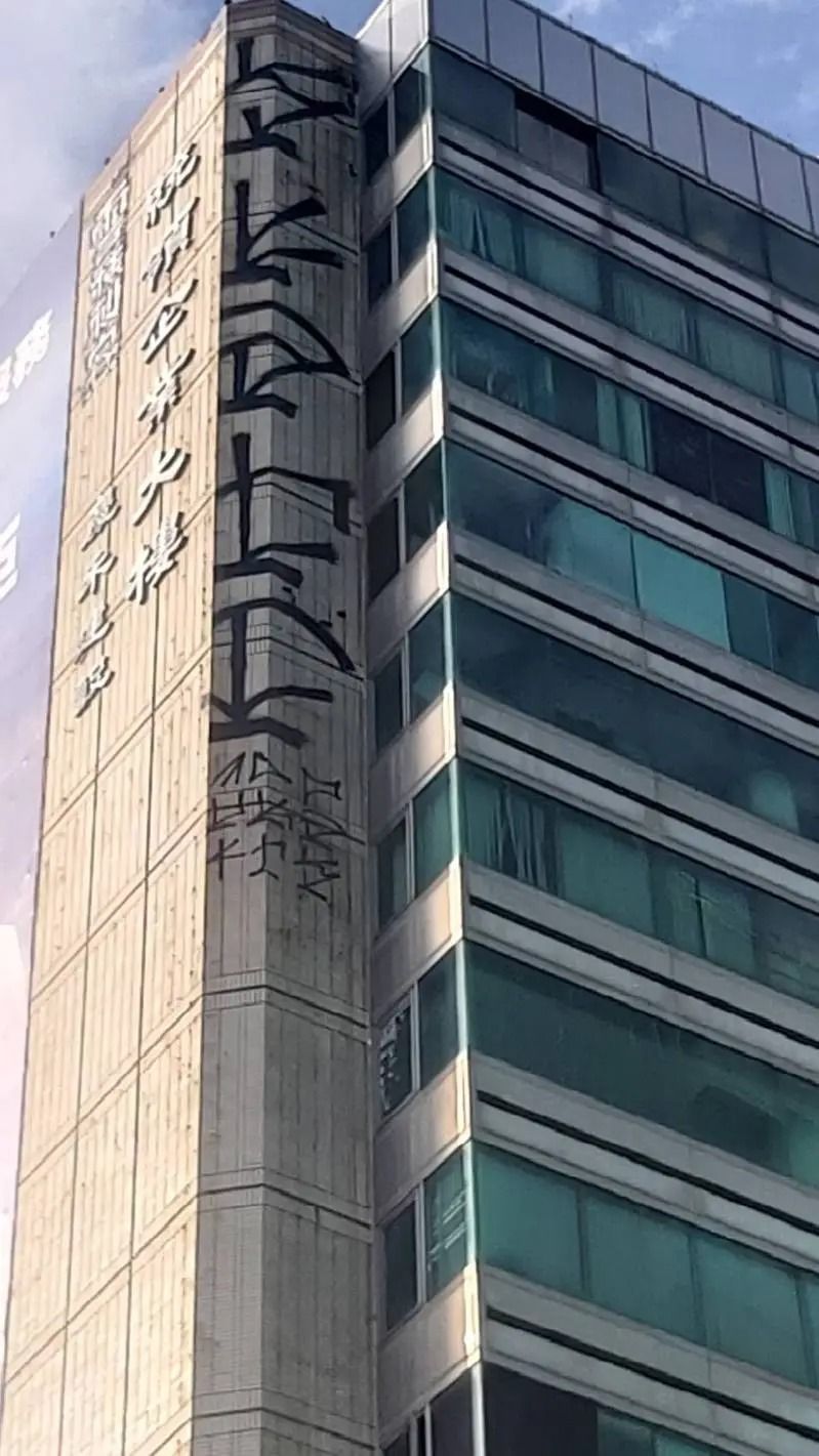 台中16層樓高的商辦大樓，外牆高處竟出現大面積塗鴉，還署名「雪糕刺客」。   圖：翻攝畫面