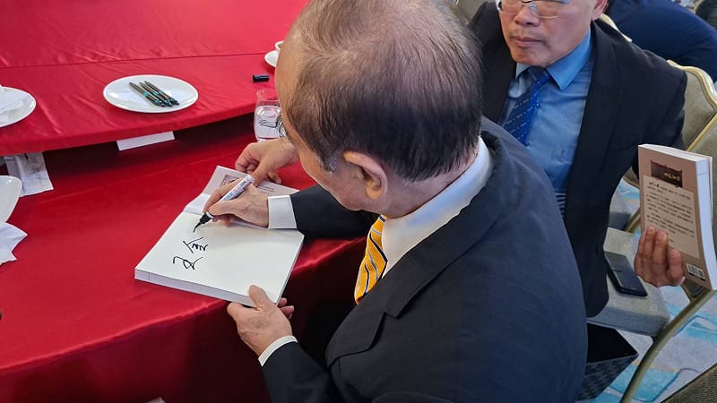 王金平在「不忘初心、五十年一瞬」紀念小冊上簽名。&nbsp;&nbsp;&nbsp;圖：孫家銘攝