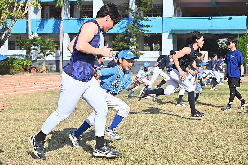 青森大學棒球隊員在以一對一教學耐心示範鼓岩國小球員。&nbsp;&nbsp;&nbsp;圖：高雄市行國處/提供