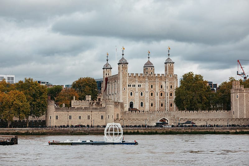 「倫敦眼」摩天輪預計至2029年執行座艙更新升級工程，期間將陸續有卸下的座艙沿著泰晤士河被運往工廠受檢施工。圖為被卸下的座艙途經倫敦另一知名地標「倫敦塔」古堡。&nbsp;&nbsp;&nbsp;圖：倫敦眼提供