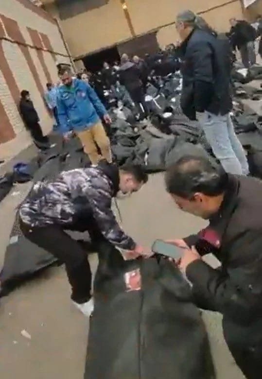 法醫中心的停車場甚至外圍街道上，密密麻麻地堆滿了大量未及安葬的遺體，屍袋數量多到連路面都看不見。&nbsp;&nbsp;&nbsp;圖：翻攝X（前推特）