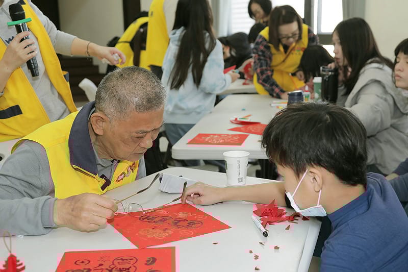 昇恆昌免稅商店董事長江松樺「江爺爺」（左），與院生手寫新年春聯。&nbsp;&nbsp;&nbsp;圖：昇恆昌免稅商店／提供