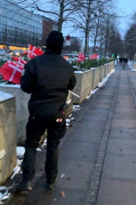  一段由丹麥媒體錄下的影片顯示，美使館保安人員於前（27）日將寫有 44 名陣亡士兵姓名的旗幟從盆栽中拔除並清空。 圖：翻攝自 X 