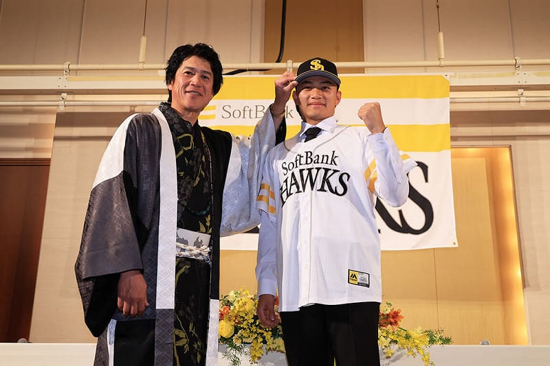 台灣投手徐若熙（右）29日在日本出席日職福岡軟銀鷹隊舉辦的加盟記者會，會中並由軟銀鷹隊首席棒球總管（CBO）城島健司（左）為他戴上球帽。（福岡軟銀鷹提供）中央社記者蘇志畬傳真　115年1月29日&nbsp;&nbsp;&nbsp;