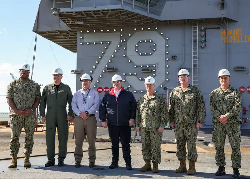 2025 年 4 月 16 日，美國海軍部長約翰·費蘭與美國海軍和 HII 紐波特紐斯造船廠的領導層在約翰·F·肯尼迪號（CVN 79）預備役艦艇島前合影。 圖:翻攝自HII
