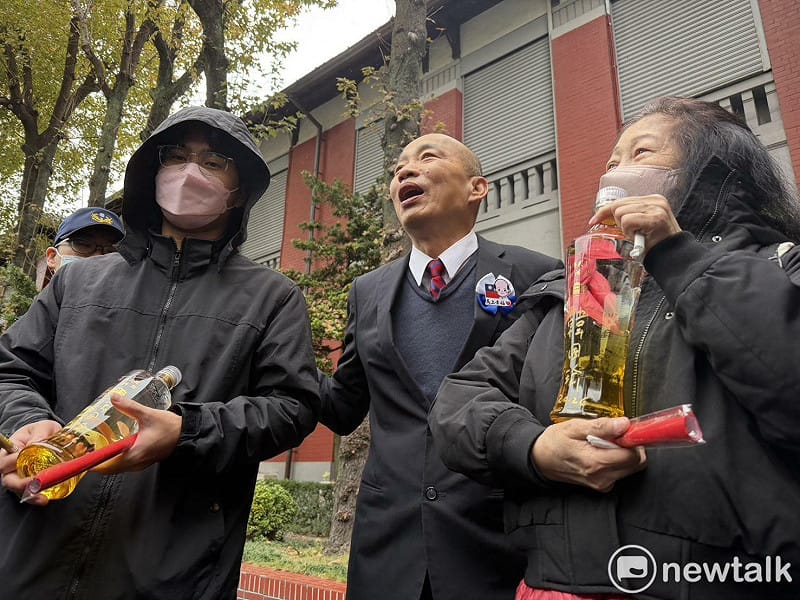 韓國瑜幫一對母子在立法院紀念酒上簽名。 圖:高逸帆/攝 韓國瑜幫一對母子在立法院紀念酒上簽名。 圖:高逸帆/攝