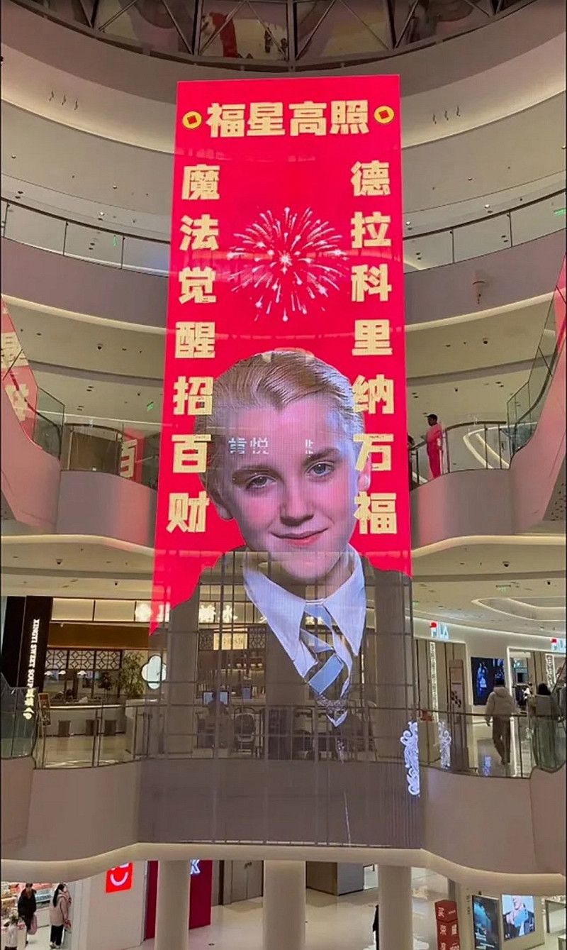 中國河南省中部一處購物中心懸掛正中央以跩哥・馬份為主角的電子對聯。&nbsp;&nbsp;&nbsp;圖：翻攝自 X @kevje4nkitty